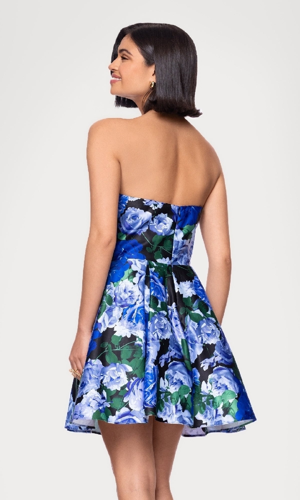 Woman wearing the Blondie Nites 5592BN Strapless Print Hoco Dress, featuring a flared skirt and floral design, posing with her back and head turned slightly to the side—a stylish, affordable choice for any semi-formal occasion.